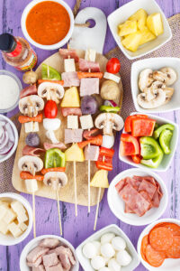 Skewers of Raw Pizza Kabobs, including potatoes, mushroom, cheese, pineapple and more