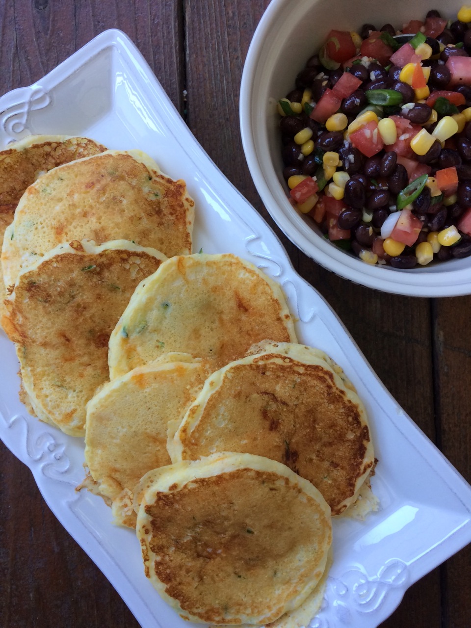 Dinner pancakes on a white plate with a side bowl of black bean salsa