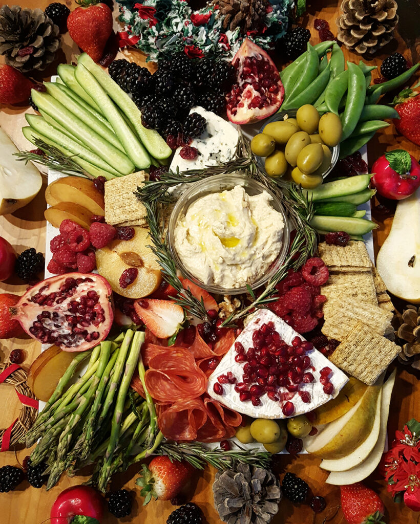 Grazing board filled with cheese, dip, fruits and veggies and breads