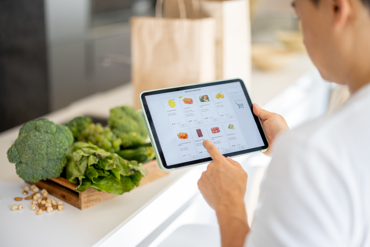 Man watching groceries in online store on digital  tablet.