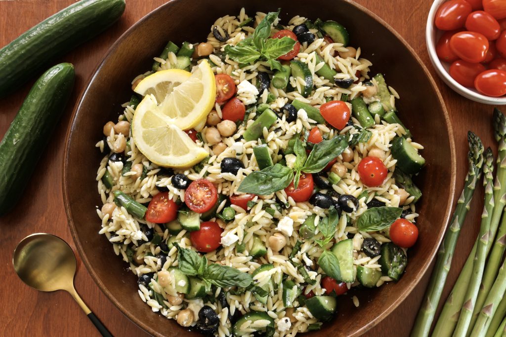 A bowl of lemon orzo pasta on a wooden table