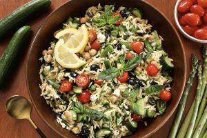 A bowl of lemon orzo pasta on a wooden table